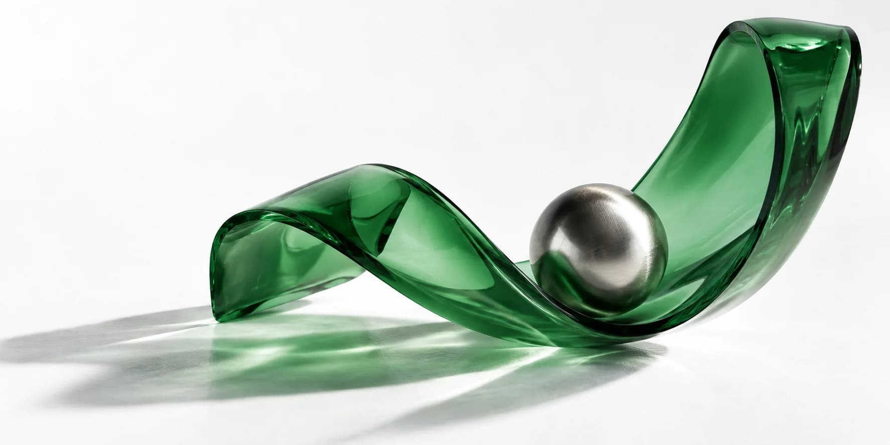 An emerald glass ribbon lifting a polished silver sphere